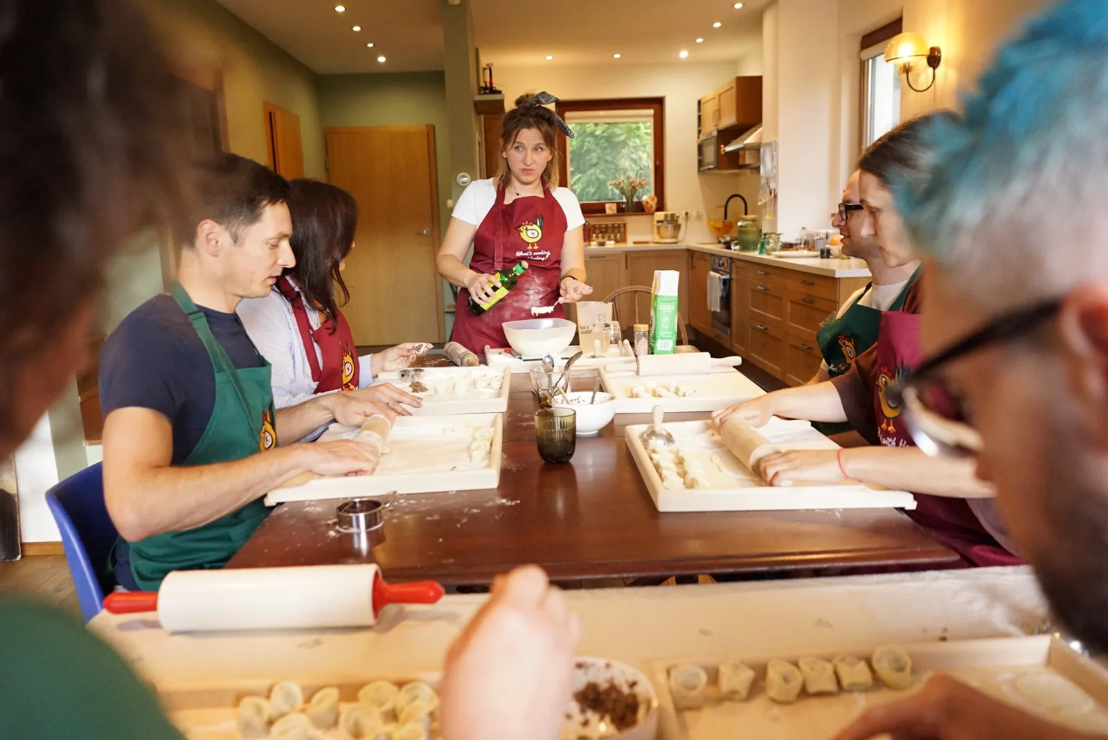 A group making pierogi together at a long table